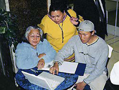 Photo of Tommy Akulukjuk of Pangnirtung (Pangnirtuuq), demonstrating how to use the computer to display archival photographs at the Project Naming event in Ottawa.