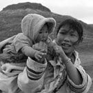 Photo de Uksawalli et son bébé avec une jeune fille inuite en route pour l'église, Cape Dorset (Kinngait), Nunavut, août 1961
