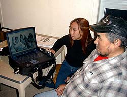 Photo de Sheba Awa, chercheuse sur le terrain, montrant des photographies à Eugen Ipkangnak, un aîné, Igloolik (anciennement Iglulik) hiver 2001-2002