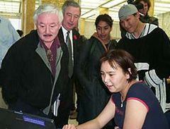 Photo of Nunavut Commissioner Peter Irniq and National Archivist Ian E. Wilson watching as Elisapee Avingaq of Igloolik (Iglulik) demonstrates the use of the laptop computer at the Project Naming event in Ottawa, November 2002.