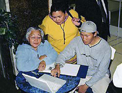 Photo de Tommy Akulukjuk, de Pangnirtung (Pangnirtuuq), montrant comment afficher les photographies archivées sur l'ordinateur, Ottawa, novembre 2002