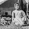 Photograph of an unidentified Aboriginal girl sitting on the ground, taken during Treaty 9 payments, region of James Bay, Ontario, 1906
