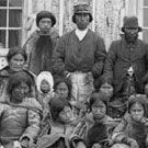 Photograph of a group of Inuit men, women and children and Reverend Peck, Pangnirtung (Pangnirtuuq), Nunavut, September 5, 1903