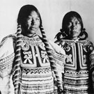 Portrait of three Inuit women wearing beaded baby-pouches. This photograph was taken in a studio at Fullerton, Nunavut, 1904