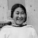 Photograph of a young Inuit woman standing in a doorway, Pangnirtung, (Pangnirtuuq), Nunavut, 1929