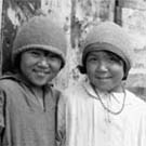 Photograph of four Inuit children standing in front of a building, Lyon Inlet, Nunavut, 1933