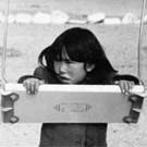 Photograph of an Inuit girl playing on a swing, Chesterfield Inlet (Igluligaarjuk), Nunavut, September 5, 1958